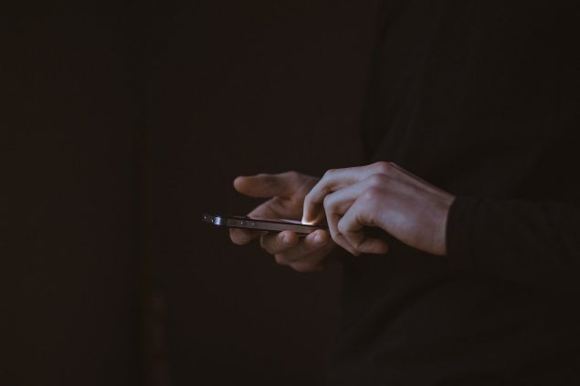 Man holding cell phone in a dark room