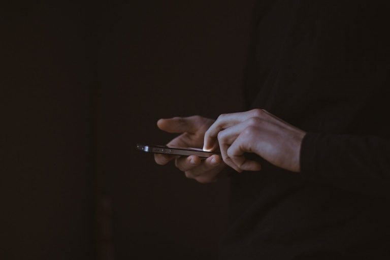 Man holding cell phone in a dark room