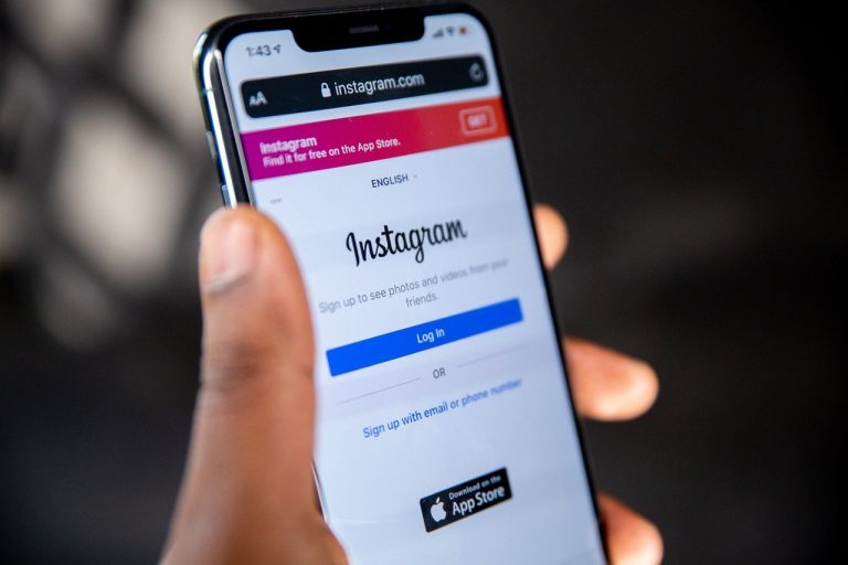 Man holding a cellphone in his left hand which is open to Instagram