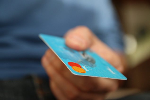 Man holding out a blue credit card