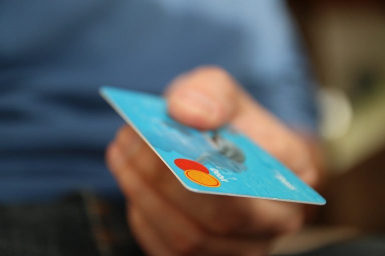 Man holding out a blue credit card