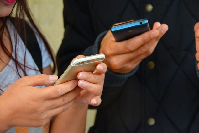 Man and woman holding cell phones.
